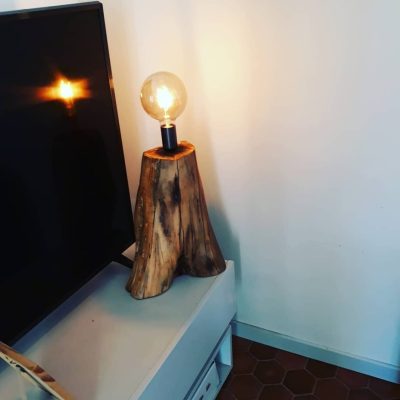 Lampe taillée dans une souche de bois brut, ampoule à filament – réalisation L'atelier du Sahuc
